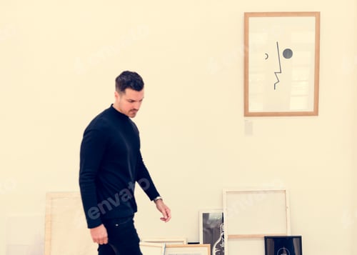Preview: Man taking care of frames in an exhibition