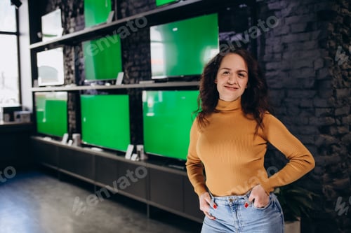 Preview: a woman in an electronics store chooses a TV on the background of TVs with a green screen