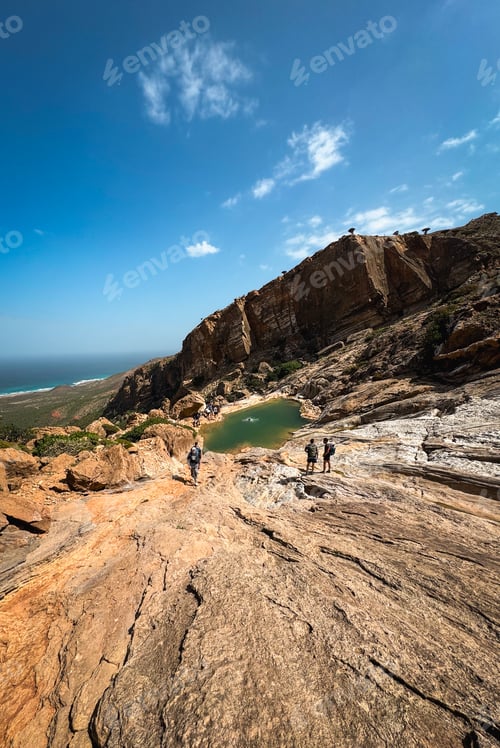 Preview: Exploring the Unique Landscape of Socotra Island with Hikers Near a Serene Pond