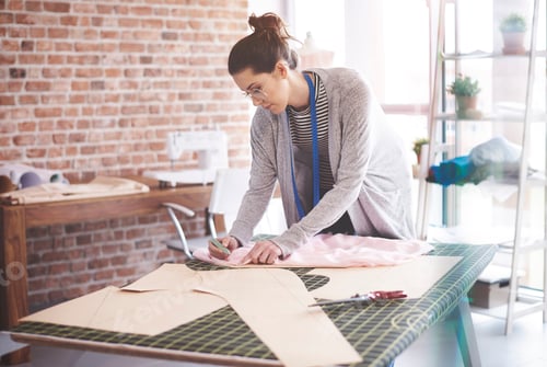 Preview: Young seamstress chalking patterns at her workshop