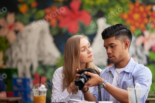 Preview: Diverse Couple Looking at Photos They Made
