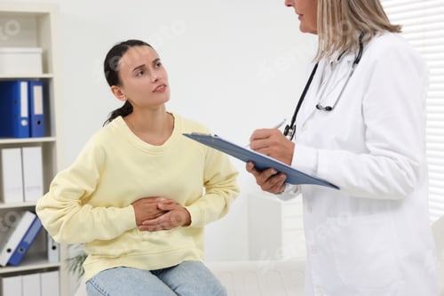 Preview: Doctor consulting patient with stomach pain in clinic, closeup