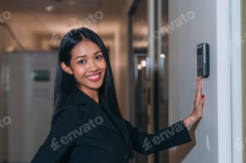 Preview: A face scanner being used by a woman to open a door at an office building.
