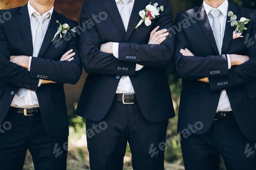 Preview: Stylish groom in suit posing with groomsmen in garden on wedding day