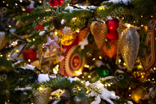 Preview: beautiful multi-colored toys on a Christmas tree against the background of lights and snow