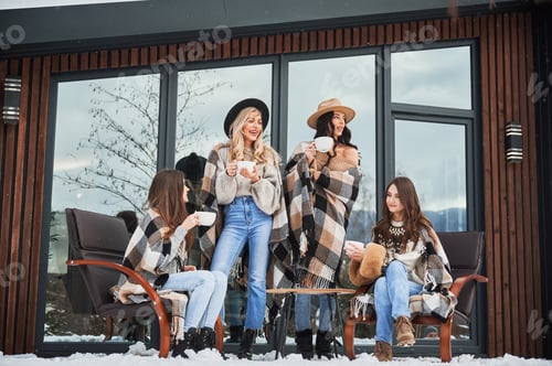 Preview: Young women enjoying winter weekends on terrace of contemporary barn house.