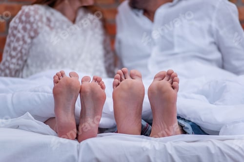 Preview: From under the white she covered two pairs of feet of couple in love. The newlyweds are having fun