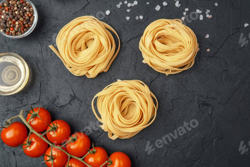 Preview: Tagliatelle pasta nests with tomatoes, oil, pepper and salt on black textured background