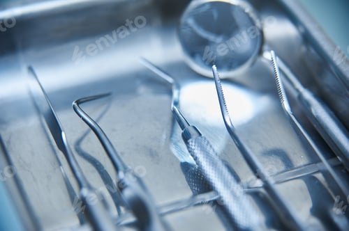 Preview: Dental instruments arranged neatly on a sterile tray in a clinical setting