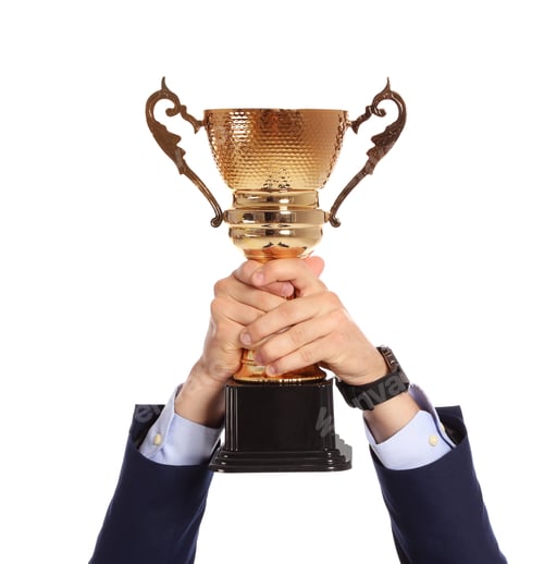 Preview: Young man holding gold trophy cup on white background, closeup