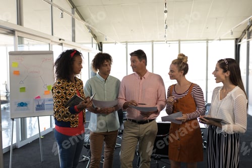 Preview: Front view of multi-ethnic business colleagues interacting with each other in a meeting at office