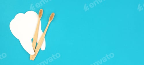 Preview: White tooth and wooden toothbrush on a blue background. Dental care concept, banner, copy space