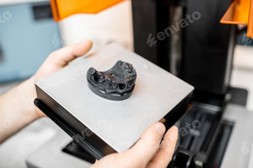 Preview: Dental technician removing jaw model from a 3d printer
