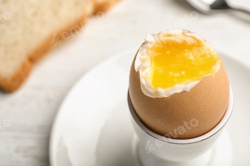 Preview: Holder with soft boiled egg on table, closeup. Space for text