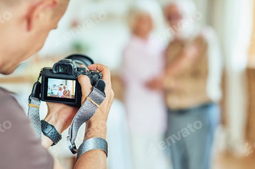 Preview: Photographer holding the camera and taking a photo session for elderly family