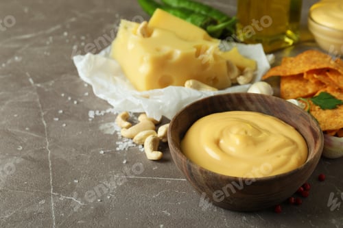 Preview: Bowls with cheese sauce and ingredients on gray textured table