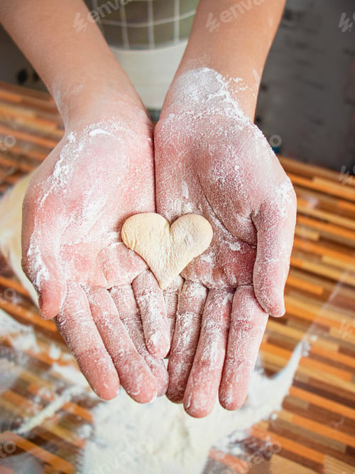 Preview: hands holding heart-shaped dough, heart-shaped cookies, close-up, baking with love on Valentine's Da