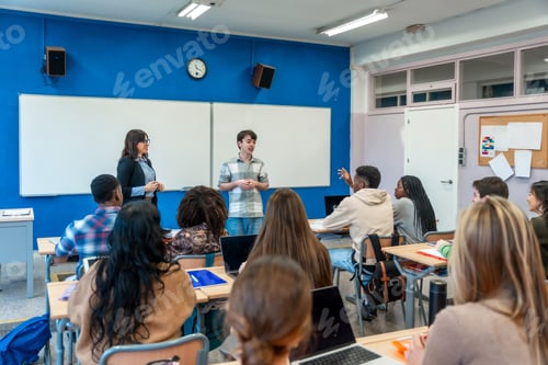 Visualização: Estudante do ensino médio fazendo apresentação em sala de aula com professores e diversos colegas