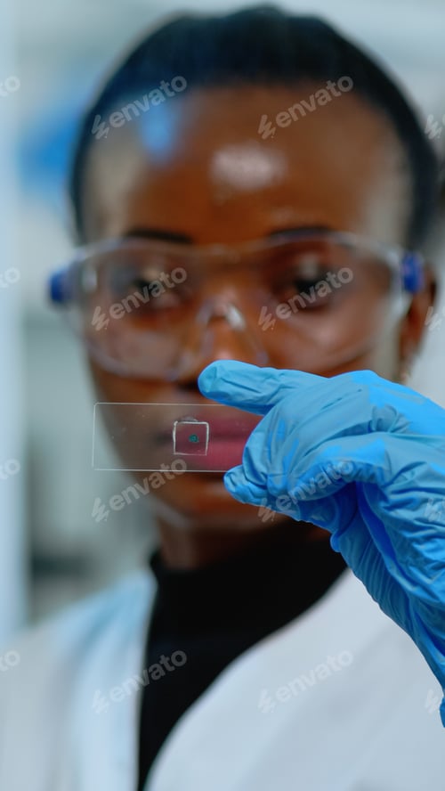 Preview: Close up of black chemistry doctor looking at virus test