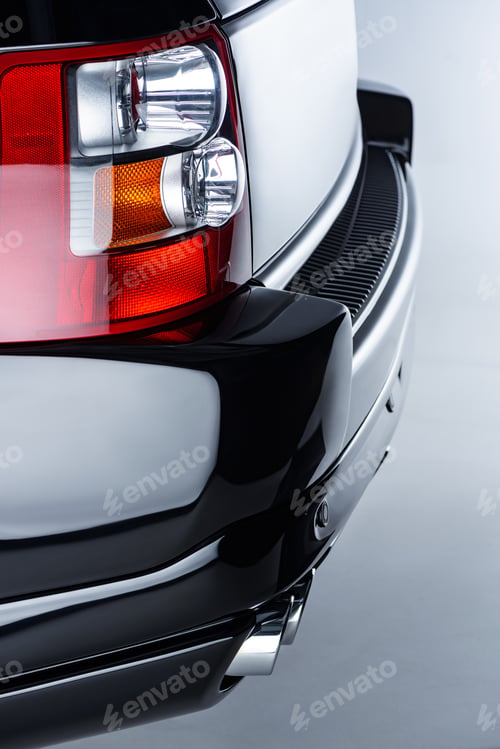 Preview: Close up view of rear headlight of luxury black car on grey backdrop