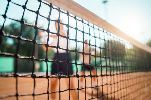 Preview: Young couple playing doubles tennis, selective focus at the net