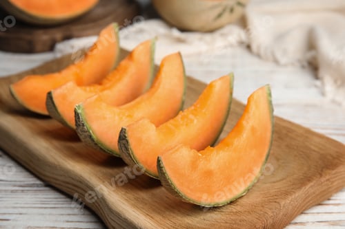 Preview: Slices of ripe cantaloupe melon in wooden tray on wooden table