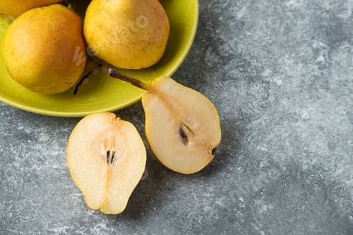 Preview: Pears cut into half on a concrete background