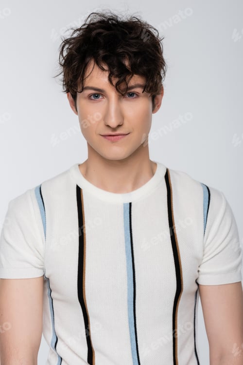 Preview: young brunette man in striped t-shirt looking at camera isolated on grey