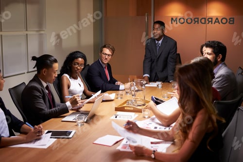 Preview: Black businessman standing to address colleagues at meeting