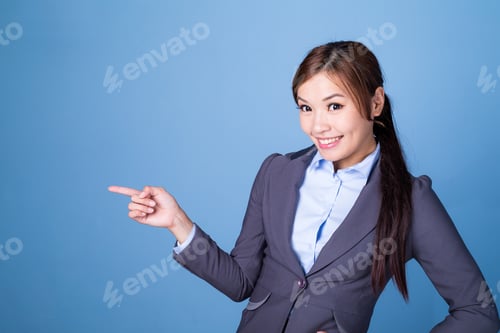 Preview: Businesswoman finger point aside over blue background