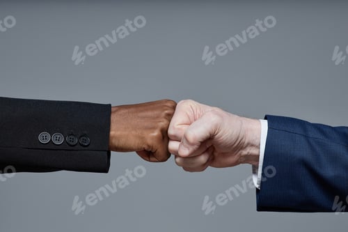 Preview: Caucasian Man and Black Woman Making Fist Bump Gesture in Studio