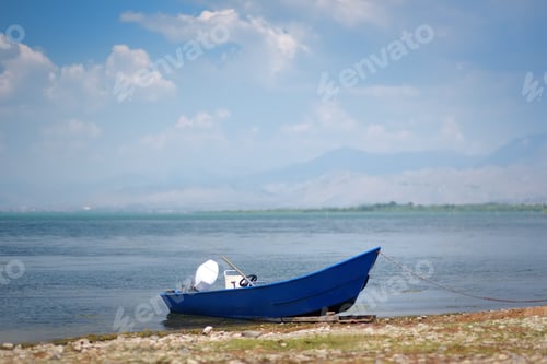 Preview: Blue motor boat on shore of wonderful Skadar lake on the background of mountains