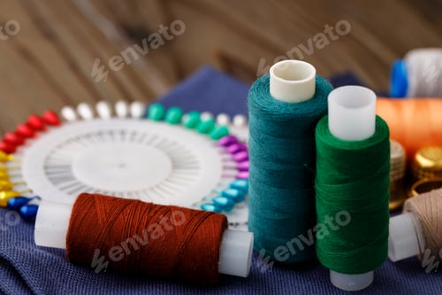 Preview: Threads and sewing accessories on brown wooden table