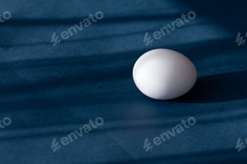 Preview: Egg on blue background with abstract shadows
