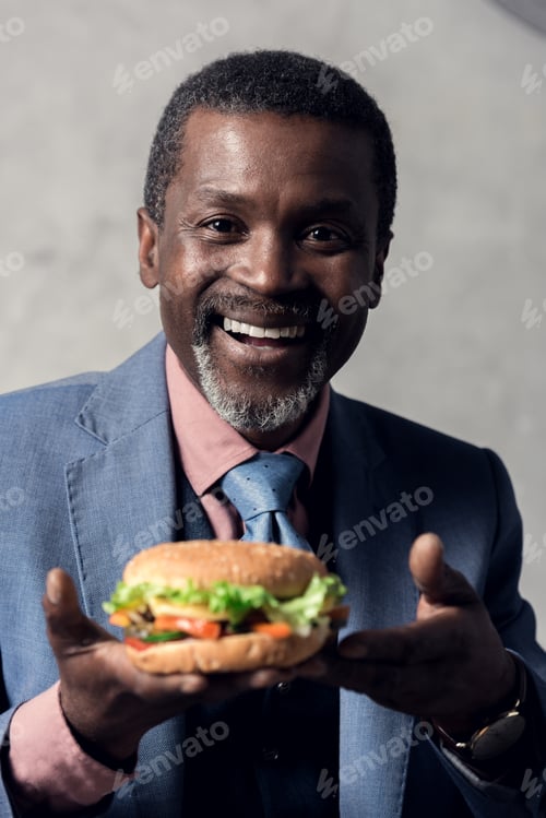 Preview: smiling middle aged african american man with hamburger