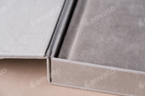Preview: A photo book in a grey cloth cover lies on the box. the concept of creating books