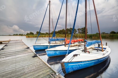 Preview: blue yachts by pier on big lake
