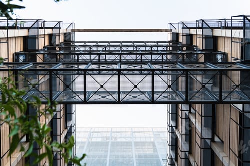 Preview: Lattice metal walkways between two modern buildings.