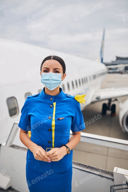Preview: Young female flight attendant staring in front of her