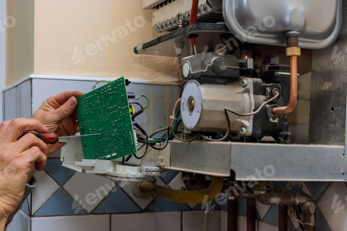Preview: Technician worker looking inside gas heater trying to fix the problem