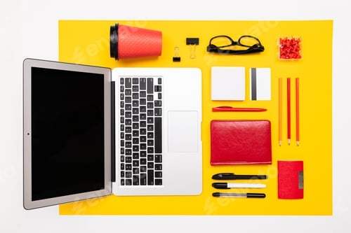 Preview: School and office supplies lie neatly on a yellow background