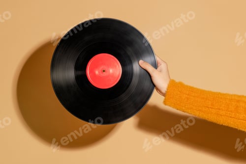 Preview: Woman holding a vinyl record on a beige background