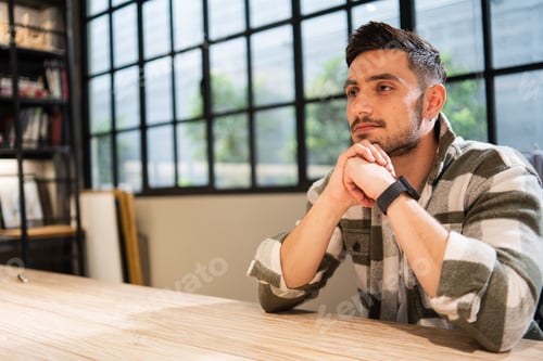 Preview: Male employee in casual thinking and sitting at desk in the office