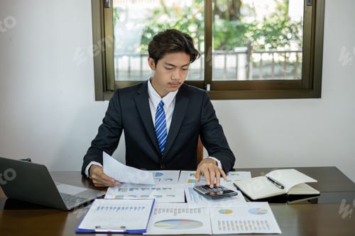 Preview: Young Asian businessman financial market analyst sits at their desks and calculate financial graphs