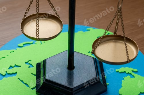 Preview: Brass scales of justice on a paper world map cutout.