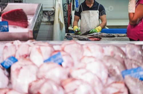 Preview: Fishmonger preparing fish inside seafood market - Focus on man gloves