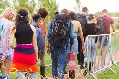 Preview: Rear View Of Friends At Entrance To Music Festival Walking Through Security Barriers
