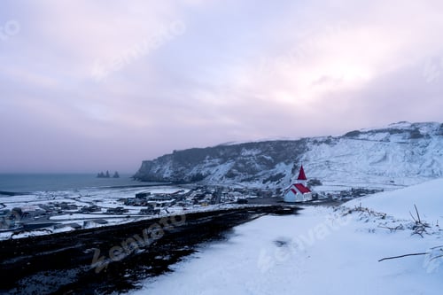 Preview: View of the Icelandic town of Vik after a snowfall at sunset