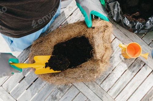 Preview: One person plants flowers in an eco-pot in the backyard.