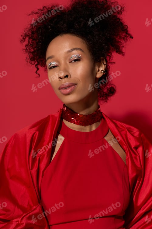 Preview: Captivating young woman radiating joy amidst a vibrant backdrop of red